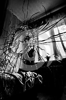 Broken glass with cracks and a hole stylized black and white film