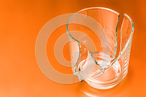 Broken glass dish on orange background. Part of home decoration that was damaged during washing