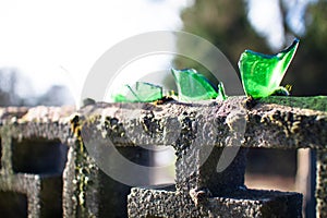 Broken glass is glued to the top of the stone wall