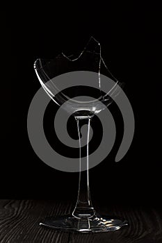 Broken glass goblet. Stands on black boards. Shot on a black background