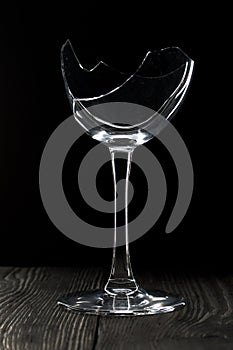 Broken glass goblet. Stands on black boards. Shot on a black background