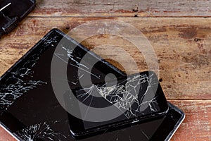 Broken glass screen on the touch screen electronic device wood background
