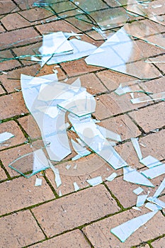 Broken glass. Shards of broken glass on the paving stones. The concept of destruction