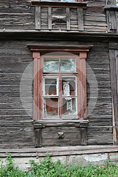 Broken glass shards in the window of an old ruined wooden house