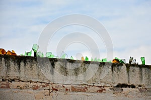 Broken glass on top of a wall photo