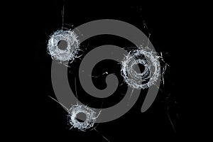 Broken glass triple bullet holes in glass isolated on black