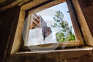 Broken glass in window in abandoned building in ghost town Pripyat Chornobyl Zone photo