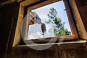 Broken glass in window in abandoned building in ghost town Pripyat Chornobyl Zone photo