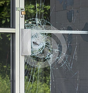 A broken glass window in an aluminum frame door