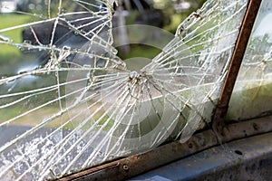 Broken glass window of an old rusty car