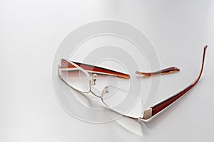 Broken glasses on a white background. Broken earband from the glasses