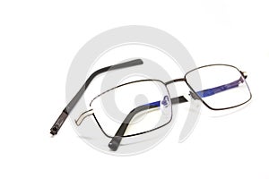 Broken glasses on white background. Eye glasseswith thin metal rim after accident.