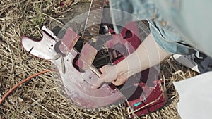 Broken guitar on the grass. Stock. The concept of forgetting classical music