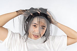 Broken hair, beautiful sad young woman with long disheveled hair, closeup photo of female model holding messy unbrushed dry hair