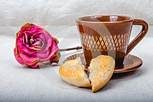 Broken heart cookies, cup of coffee, dried rose