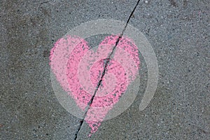 Broken heart drawn on sidewalk with chalk