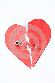 Broken heart joined with safety pin