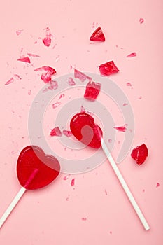 Broken heart lollipop on pink background