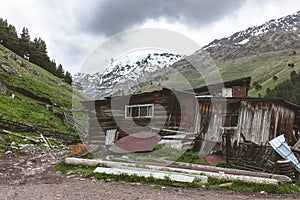 BROKEN HOUSE BEHIND HIGH SNOWY MOUNTAINS