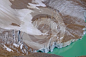 Broken ice of glacier reflection in alpine lake.