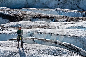 Hombre en verde chaqueta de pie de glaciar en 