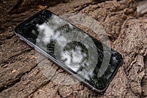 Broken iphone screen on the tree bark