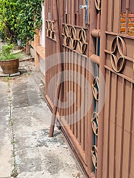 Broken iron brown slice door gate house. lock entrance for safety property