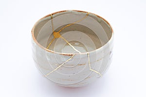 Broken Japanese handmade bowl restored with the antique japanese kintsugi real gold technique photo