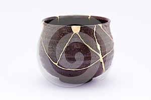 Broken Japanese handmade bowl restored with the antique japanese kintsugi real gold technique photo