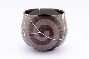 Broken Japanese handmade bowl restored with the antique japanese kintsugi real gold technique photo