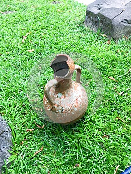 broken jug with green grass background