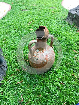 broken jug with green grass background