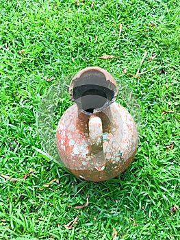 broken jug with green grass background