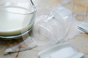 Broken jug and poured milk on a table