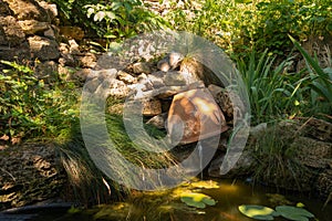 Broken jug water feature with vase. Pond.