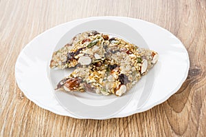 Broken kozinak with almonds and raisins in white plate