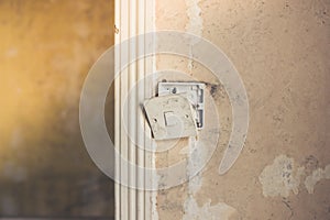 Broken light switch on dirty wall