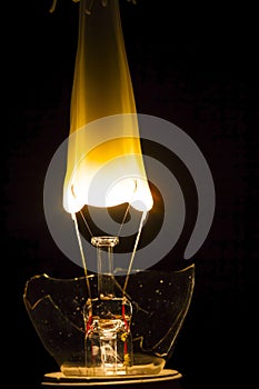 Broken lightbulb with filament bursting into flame