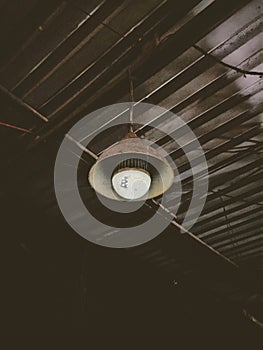 A broken low light dimming LED light bulb with dirty old interior indoor