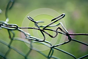 Broken mesh fence as a symbol of defencelessness