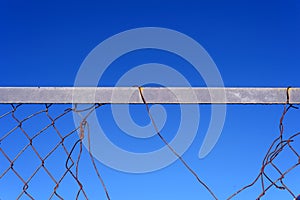 Broken Metal Wire Fence and Blue Sky Background