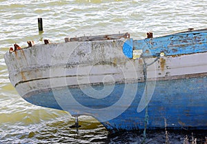 Broken migrant boat shipwreck washed ashore after sea crossing photo