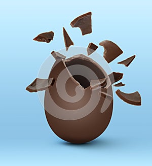 Broken milk chocolate egg on light blue background