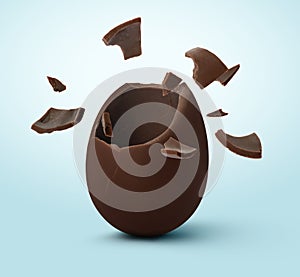 Broken milk chocolate egg on light blue background