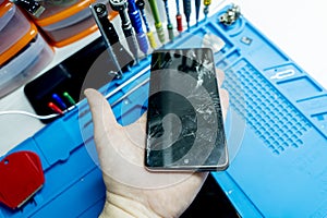 A broken mobile phone screen in the master`s hand