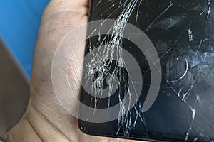 A broken mobile phone screen in the master`s hand
