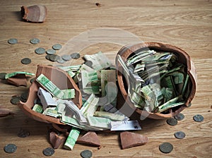 A broken Money box with Saudi Riyal banknotes and coins 2
