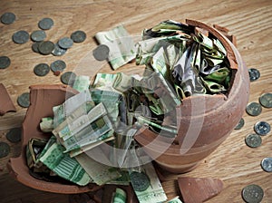 A broken Money box with Saudi Riyal banknotes and coins 4