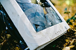 Broken monitor.The old television in the woods is rotting and polluting nature. The concept of environmental protection