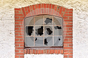 Broken muntin window with shattered glass of old abandoned building